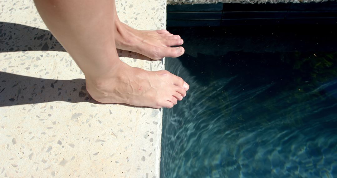 Bare Feet on Pool Edge Ready to Dive into Refreshing Water