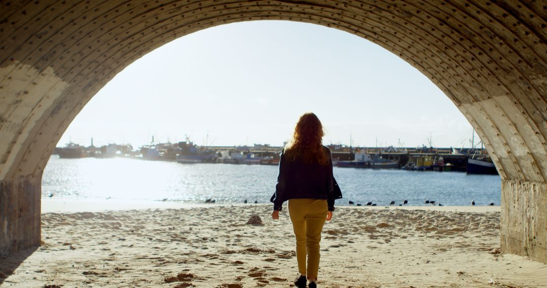 Woman Walking Through Tunnel Towards Beach at Sunrise - Free Images, Stock Photos and Pictures on Pikwizard.com