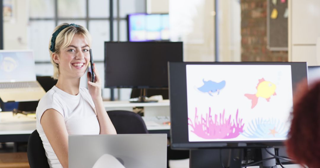 Woman Collaborating in Open-Plan Office with Vibrant Digital Designs