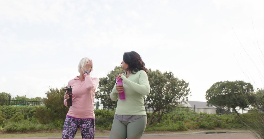 Two Women Engaging in Morning Walk with Water Bottles - Free Images, Stock Photos and Pictures on Pikwizard.com