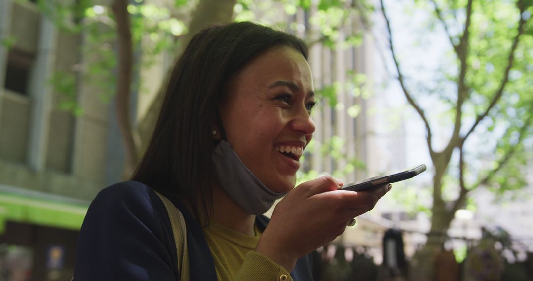 Young woman laughing while using smartphone voice assistant outdoors - Free Images, Stock Photos and Pictures on Pikwizard.com