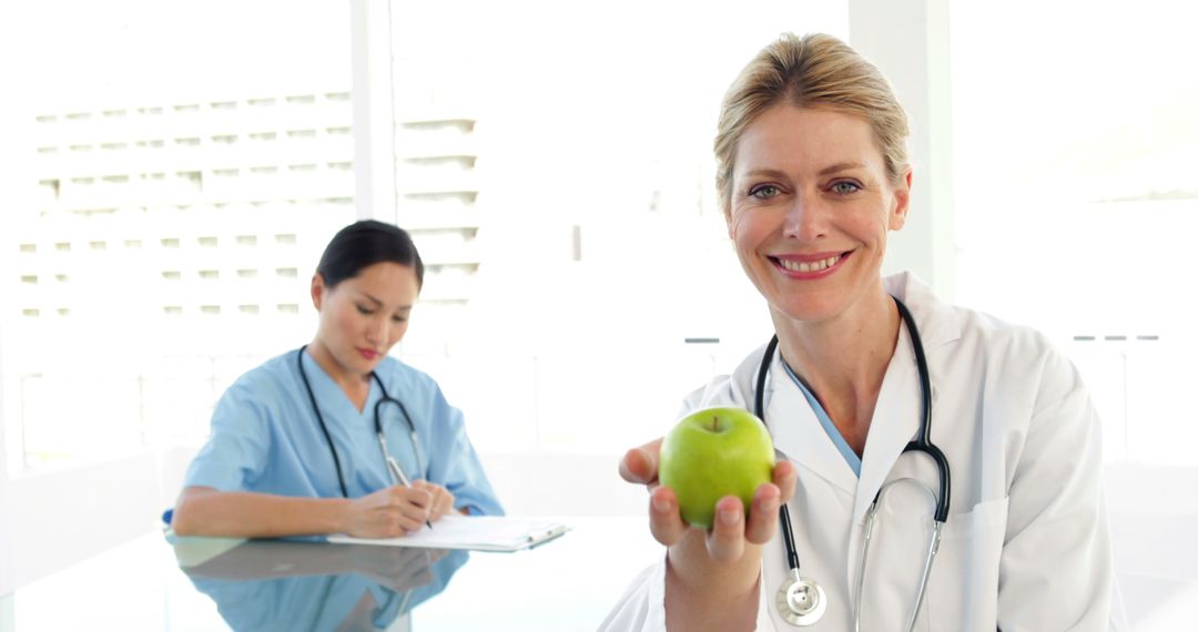 Smiling Doctor Offering a Healthy Choice with a Green Apple