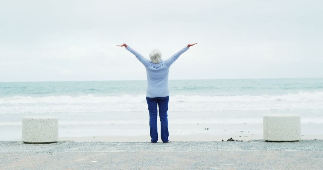 Senior Woman Enjoying Coastal View with Open Arms by the Ocean - Free Images, Stock Photos and Pictures on Pikwizard.com