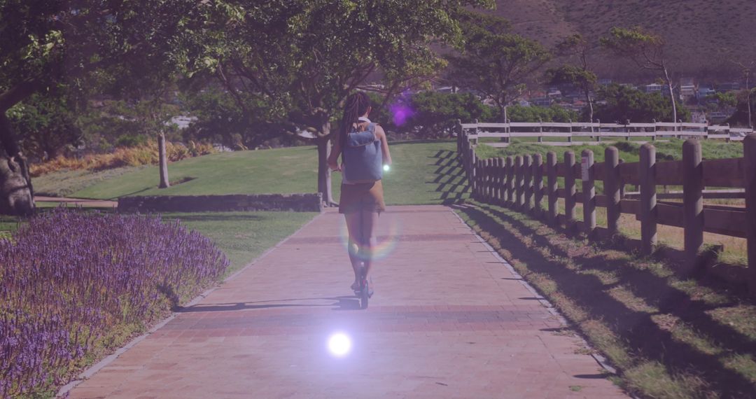 Woman Enjoying Sunny Day on Scooter in Scenic Park