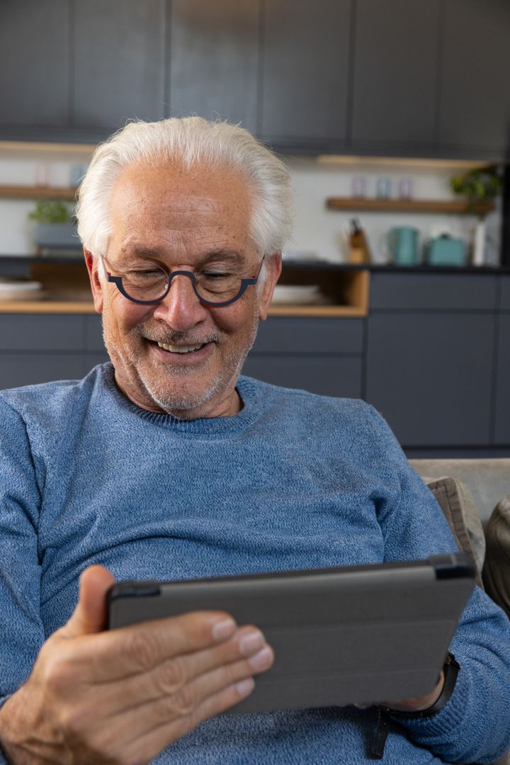 Senior Man Relaxing at Home with Tablet Technology