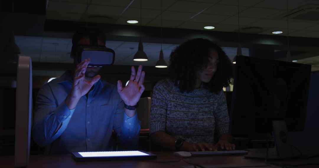 People Experimenting with VR and Typing in Dimly Lit Office - Free Images, Stock Photos and Pictures on Pikwizard.com