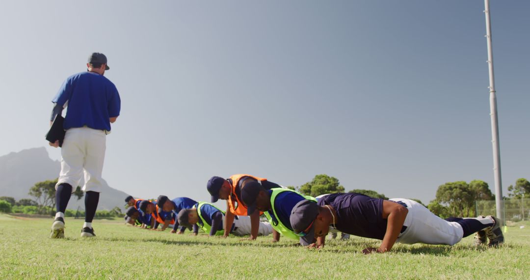 Youth baseball players doing push-ups during outdoor training session - Free Images, Stock Photos and Pictures on Pikwizard.com