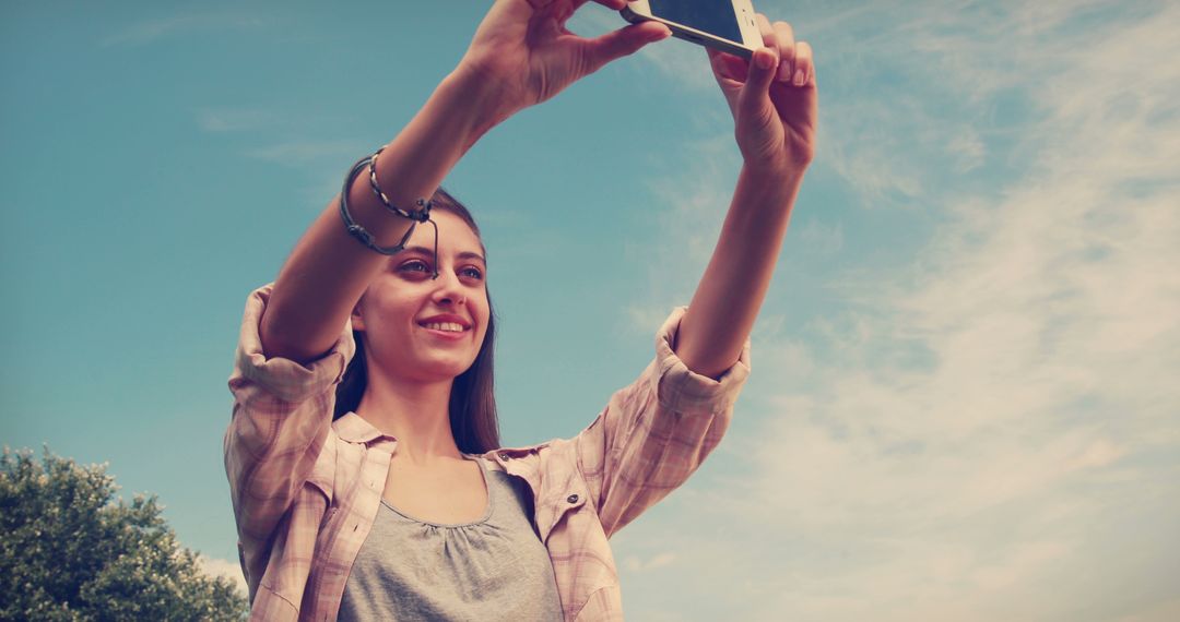 Woman Taking Selfie Outdoors on Sunny Day, Capturing Happy Moments - Free Images, Stock Photos and Pictures on Pikwizard.com