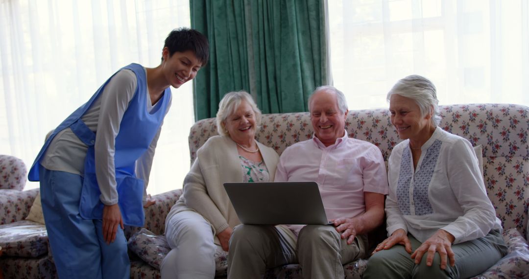 Seniors Enjoying Time with Nurse, Using Laptop in Nursing Home