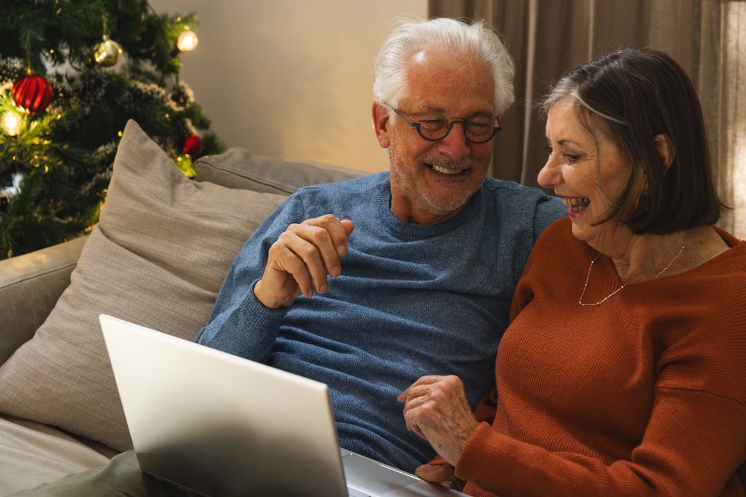 Senior Couple Enjoys Christmas Browsing on Laptop at Home