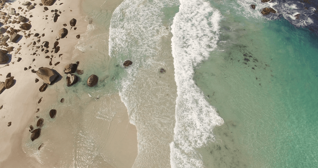 Transparent Waves and Rocks on Pristine Beach Aerial View