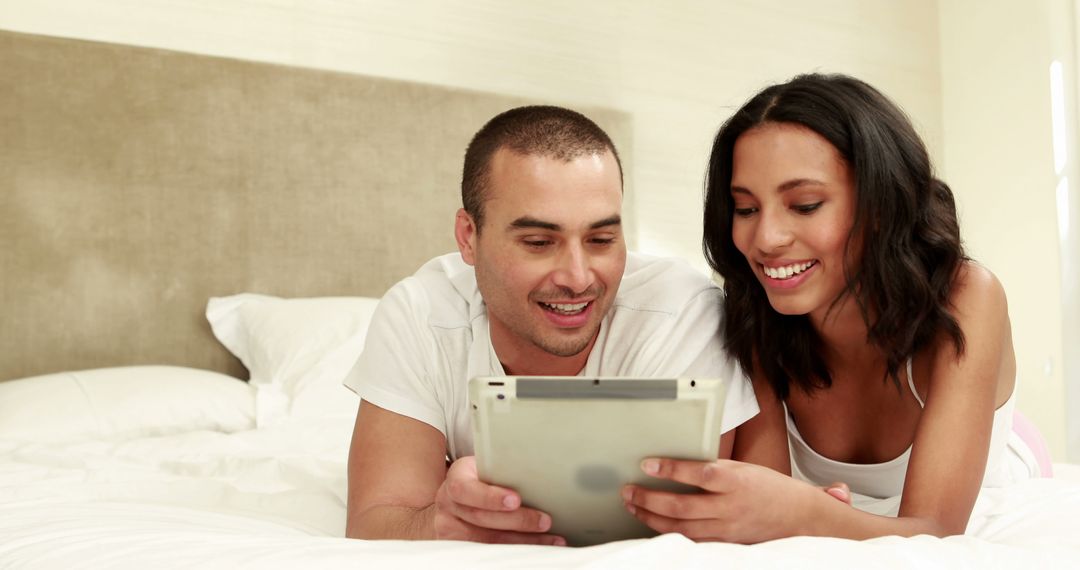 Couple Relaxing in Cozy Bedroom While Browsing Tablet Together