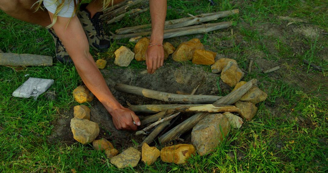Person Preparing Campfire Pit in Forest Clearing - Free Images, Stock Photos and Pictures on Pikwizard.com