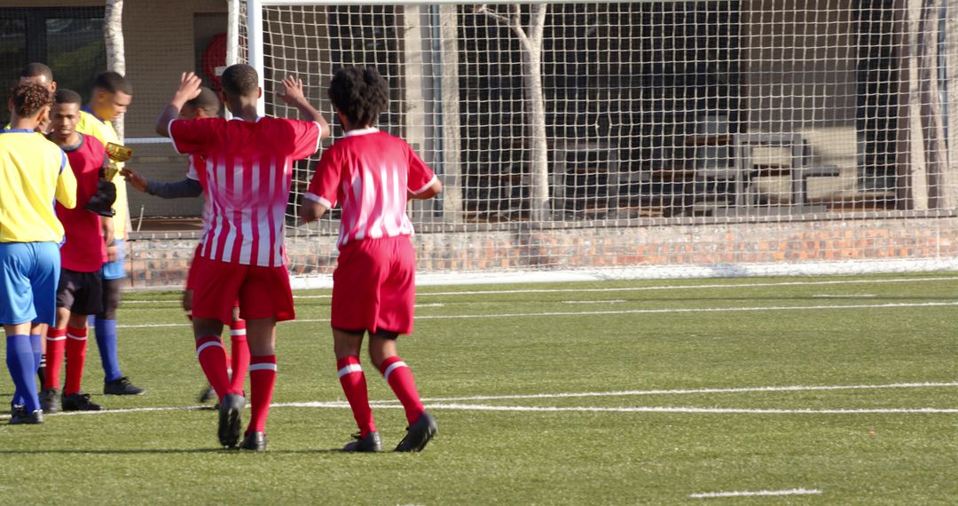 Youth Soccer Players Celebrating on Field Showing Teamwork