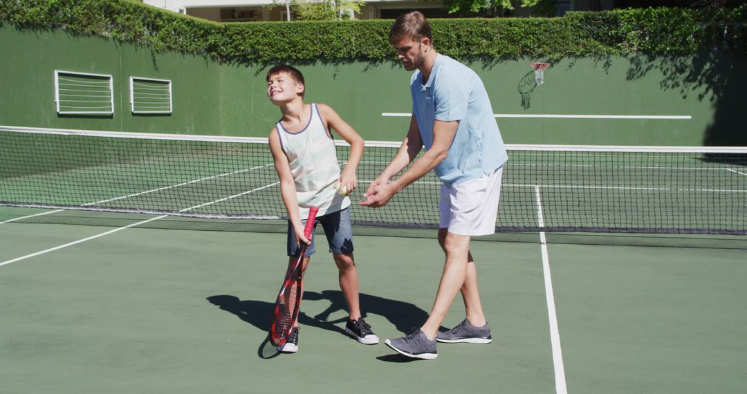 Father Teaching Son Tennis Techniques During Outdoor Practice - Free Images, Stock Photos and Pictures on Pikwizard.com