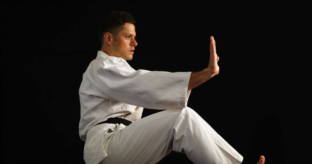 Man practicing karate against black background - Free Images, Stock Photos and Pictures on Pikwizard.com