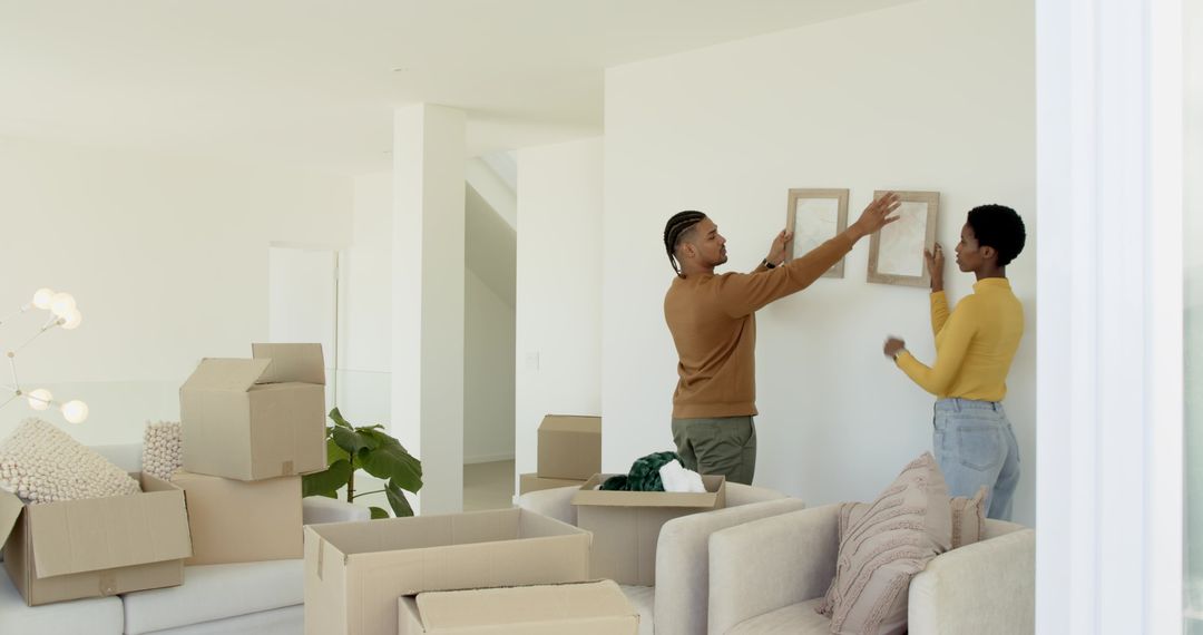 Couple Decorating New Home After Moving, Placing Picture Frames