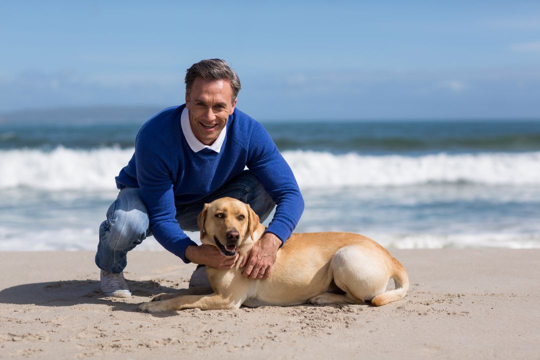 Mature man with his dog on the beach - Free Images, Stock Photos and Pictures on Pikwizard.com