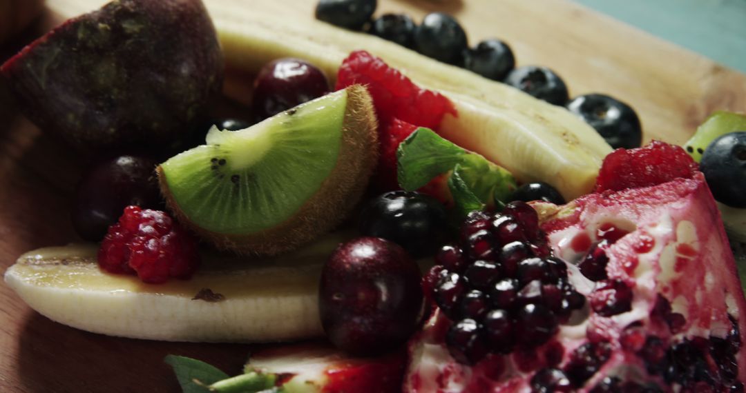 Sliced Fruits With Blueberries And Raspberries on Wooden Surface - Free Images, Stock Photos and Pictures on Pikwizard.com