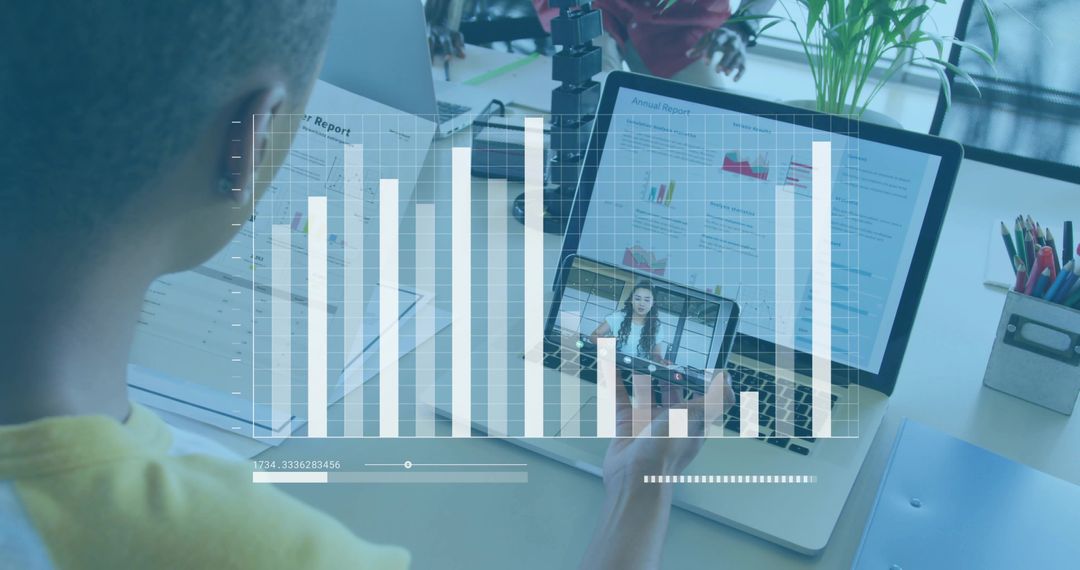 Reviewing annual report while joining video call with data dashboard overlay on laptop