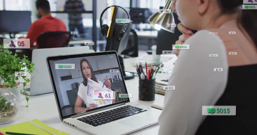Professional woman attending virtual presentation on laptop amid collaborative open office workspace