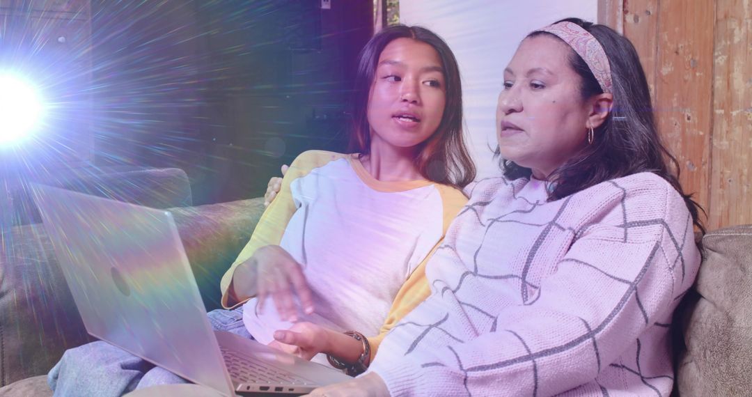 Multigenerational Asian Women Sharing Laptop on Cozy Sofa Discussing Online Content