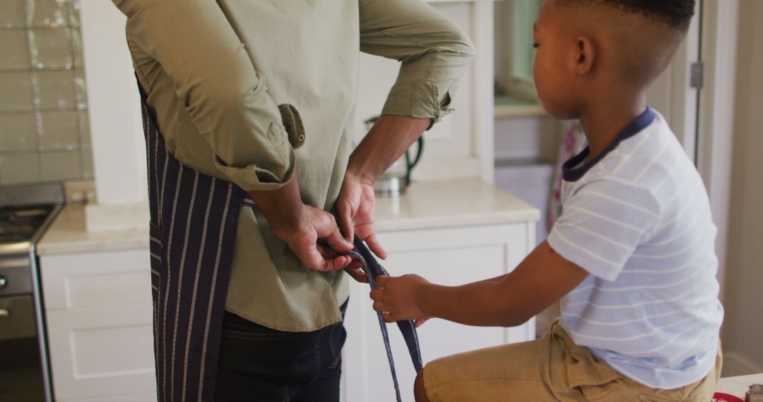 Father and Young Son Tying Apron in Kitchen - Free Images, Stock Photos and Pictures on Pikwizard.com