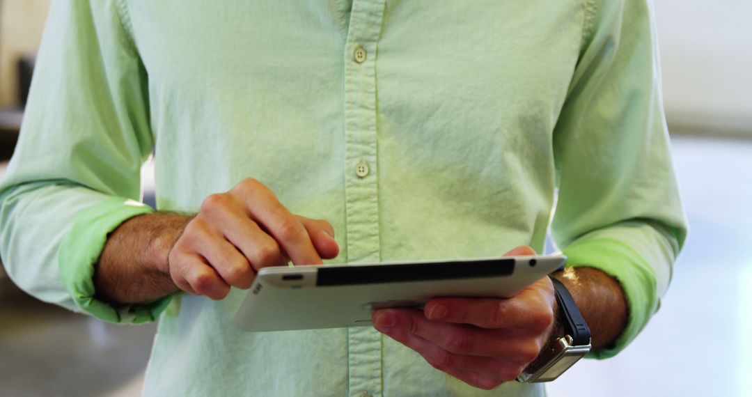 Person Using Tablet Device in Casual Green Shirt at Work - Free Images, Stock Photos and Pictures on Pikwizard.com