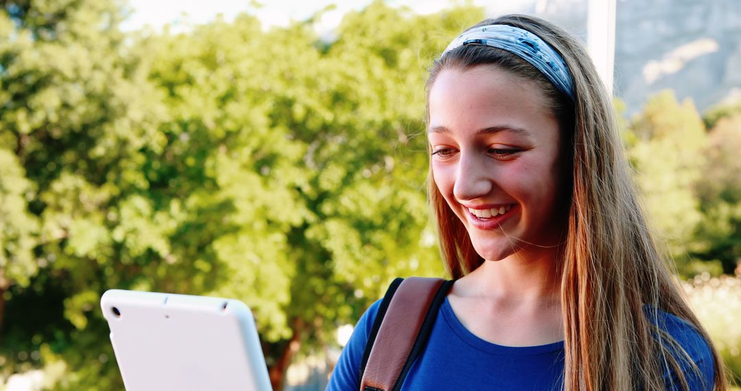 Smiling Teen Girl Using Tablet Outdoors for Online Learning - Free Images, Stock Photos and Pictures on Pikwizard.com