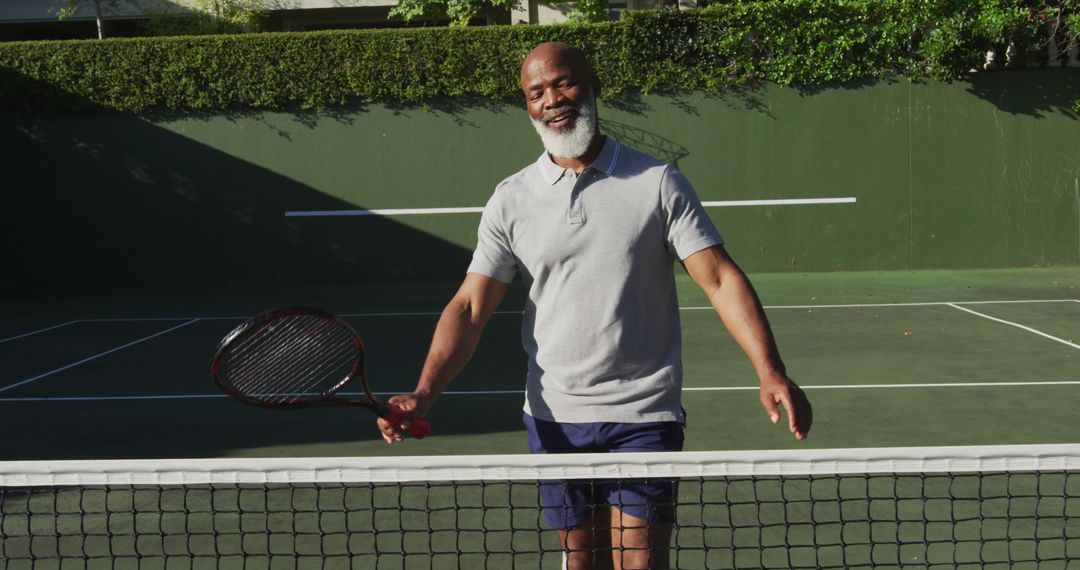 Senior Man with Tennis Racket on Outdoor Court Smiling - Free Images, Stock Photos and Pictures on Pikwizard.com