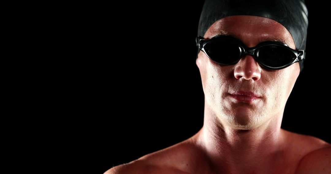 Professional Swimmer Wearing Swim Cap and Goggles in Black Studio - Free Images, Stock Photos and Pictures on Pikwizard.com