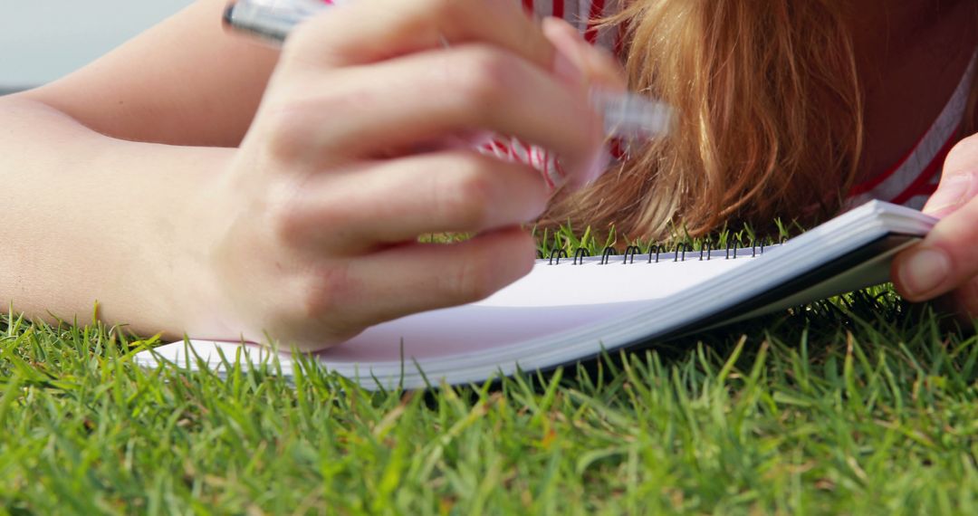 Woman Writing in Notebook While Lying on Grass - Free Images, Stock Photos and Pictures on Pikwizard.com