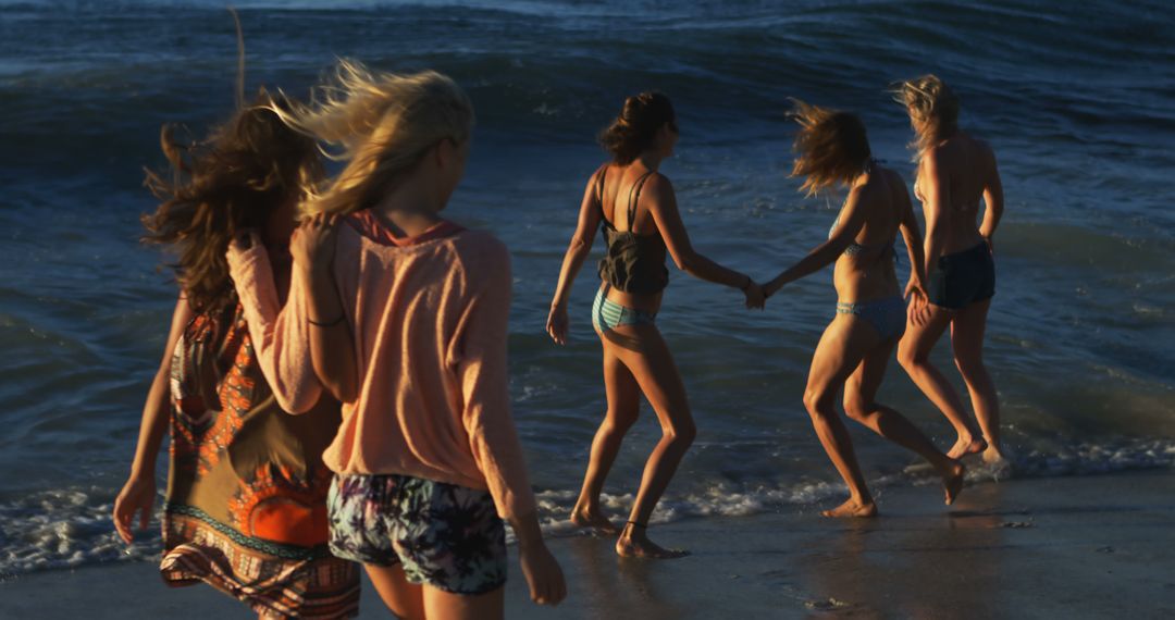 Friends Walking at Beach Shore During Sunset - Free Images, Stock Photos and Pictures on Pikwizard.com