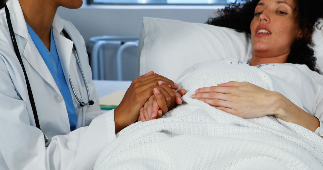 Doctor Holding Pregnant Woman's Hand During Labor in Hospital - Free Images, Stock Photos and Pictures on Pikwizard.com