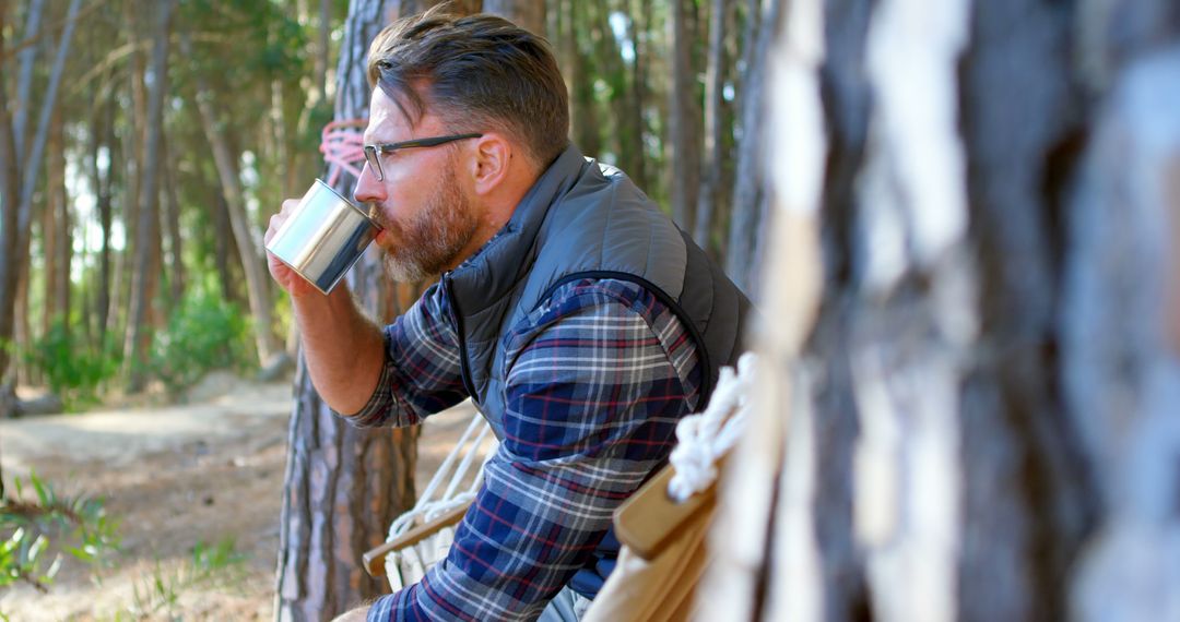 Man Drinking Coffee in Forest Wearing Plaid Shirt and Vest - Free Images, Stock Photos and Pictures on Pikwizard.com