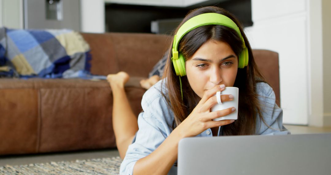 Young Woman Relaxing on Floor with Green Headphones and Cup of Coffee - Free Images, Stock Photos and Pictures on Pikwizard.com