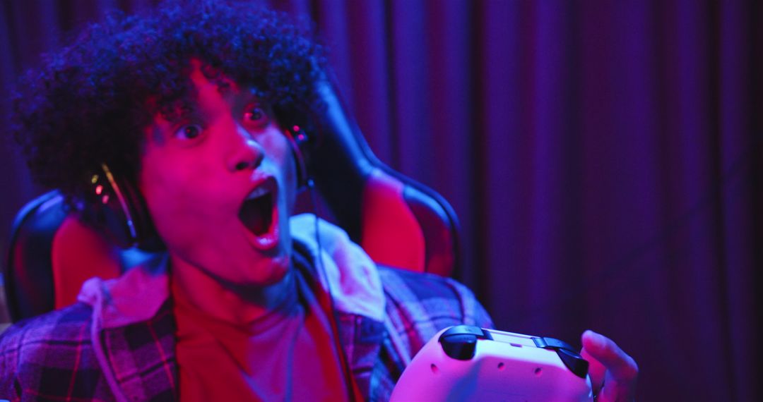 Excited Gamer Using Controller with Headphones at Night