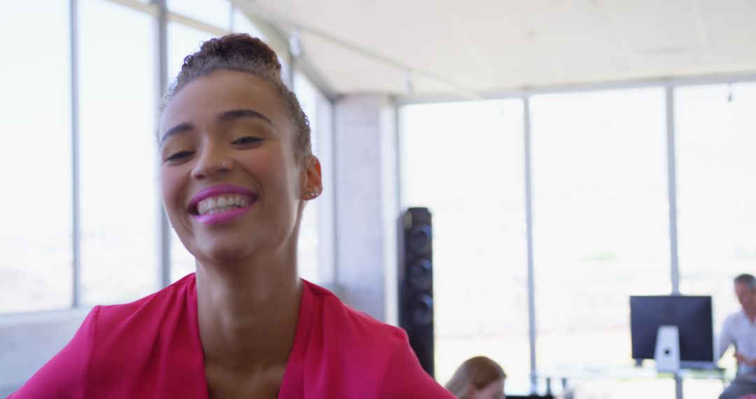 Smiling Young Woman in Pink in Bright Office Environment