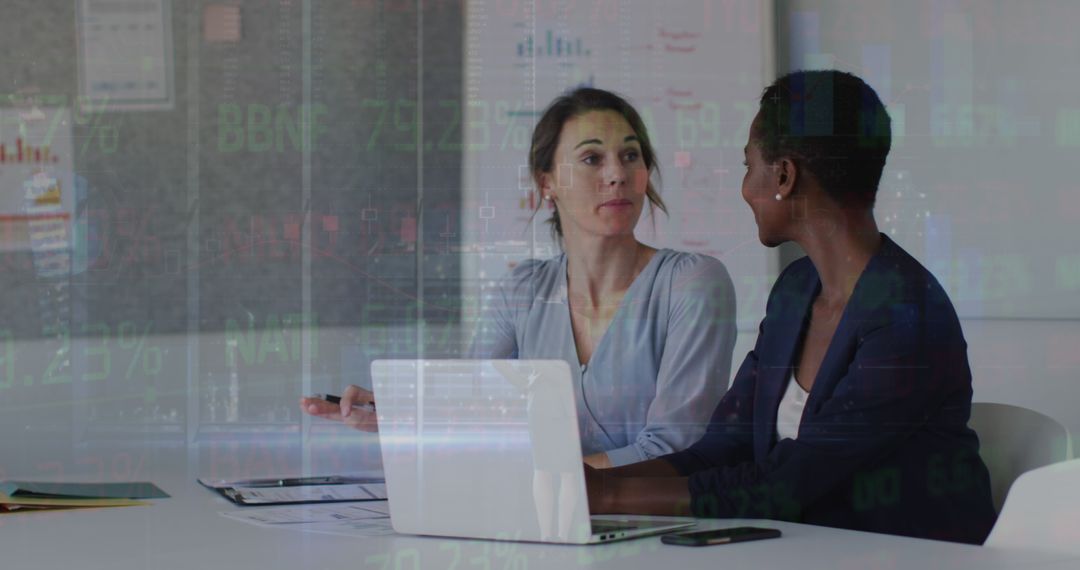 Diverse Businesswomen Strategizing in Modern Office with Financial Data Overlay