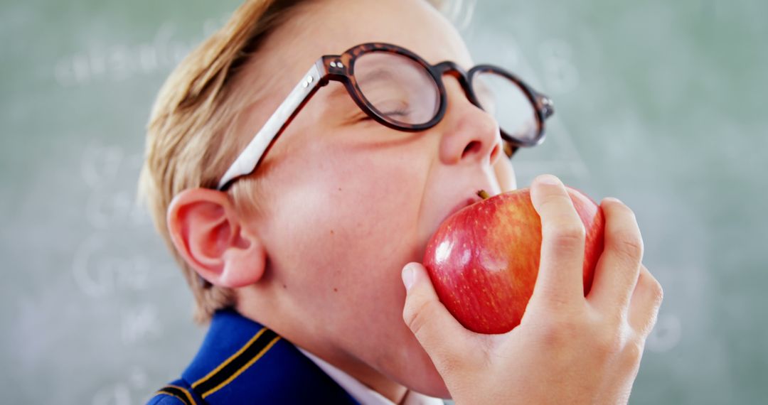 Young Boy Eating Red Apple in Classroom - Free Images, Stock Photos and Pictures on Pikwizard.com