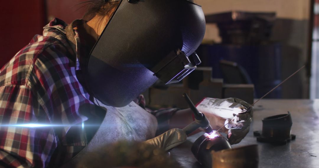 Female Welder Skillfully Soldering Metal in Workshop