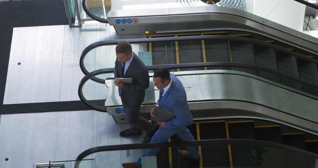 Businessmen Walking Next to Escalator in Modern Office Building - Free Images, Stock Photos and Pictures on Pikwizard.com