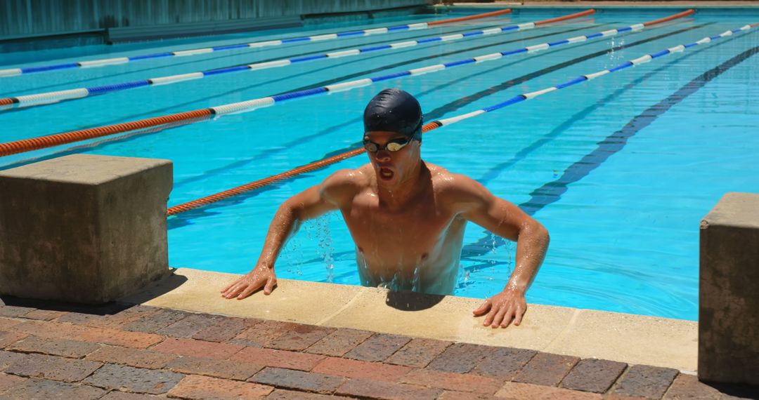 Swimmer in black swim cap emerging from outdoor swimming pool deck - Free Images, Stock Photos and Pictures on Pikwizard.com