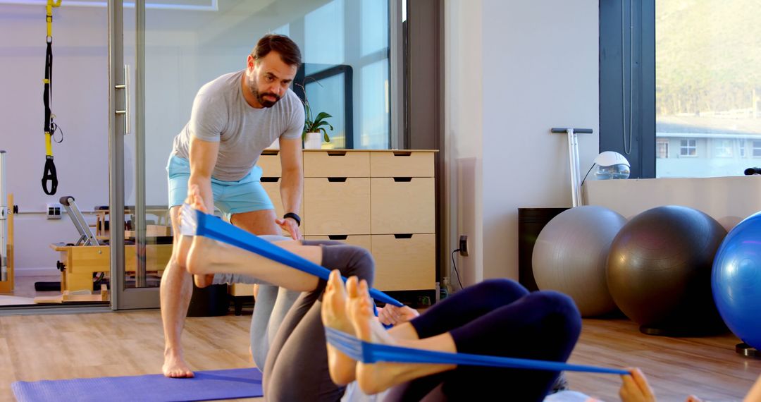 Personal Trainer Assisting Client with Resistance Band Workout - Free Images, Stock Photos and Pictures on Pikwizard.com