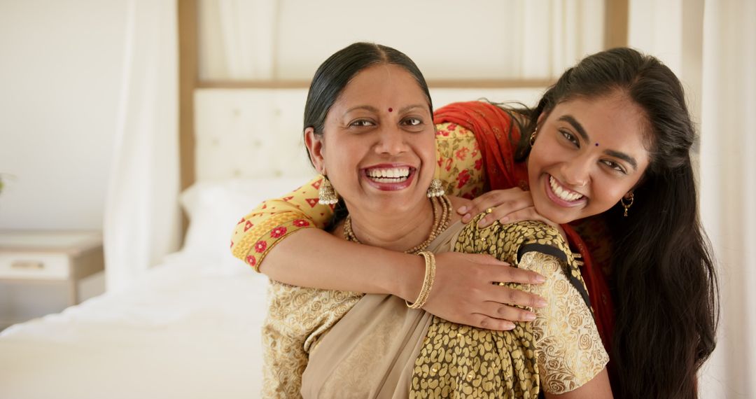 Smiling Indian Mother and Daughter Embracing in Cozy Home Setting