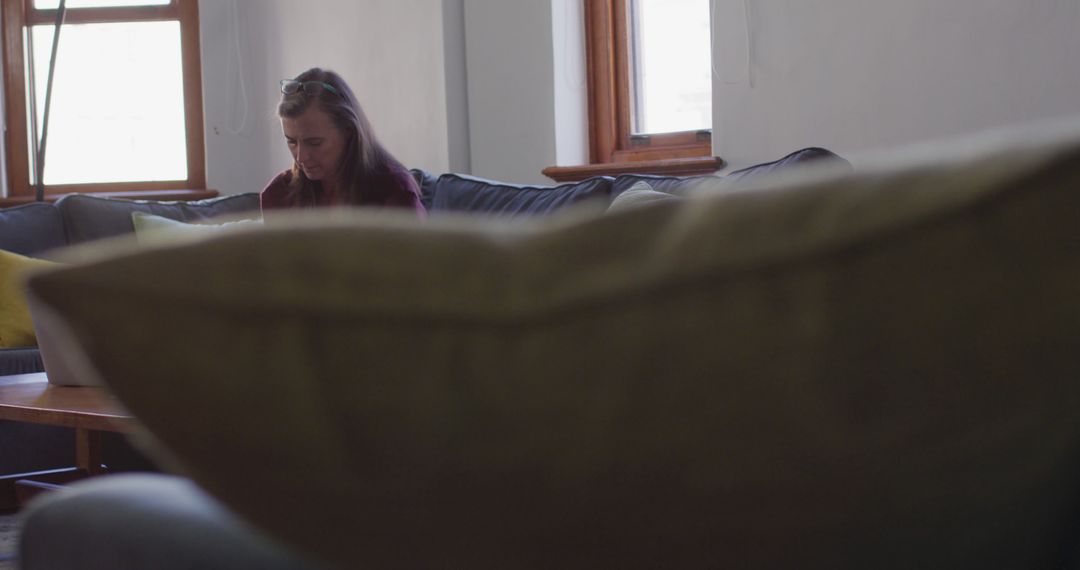 Woman Focusing Intensely on Laptop in Cozy Living Room - Free Images, Stock Photos and Pictures on Pikwizard.com