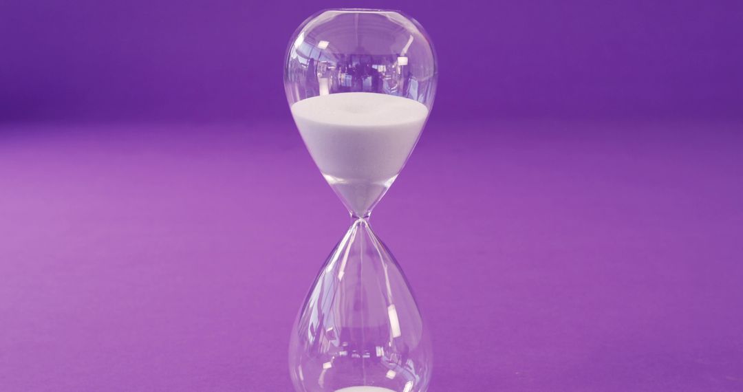 Clear Hourglass with White Sand Against Purple Background - Free Images, Stock Photos and Pictures on Pikwizard.com