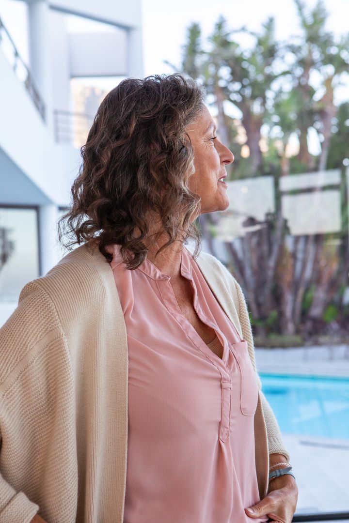 Mature Woman Relaxing by Contemporary Poolside in Soft Light