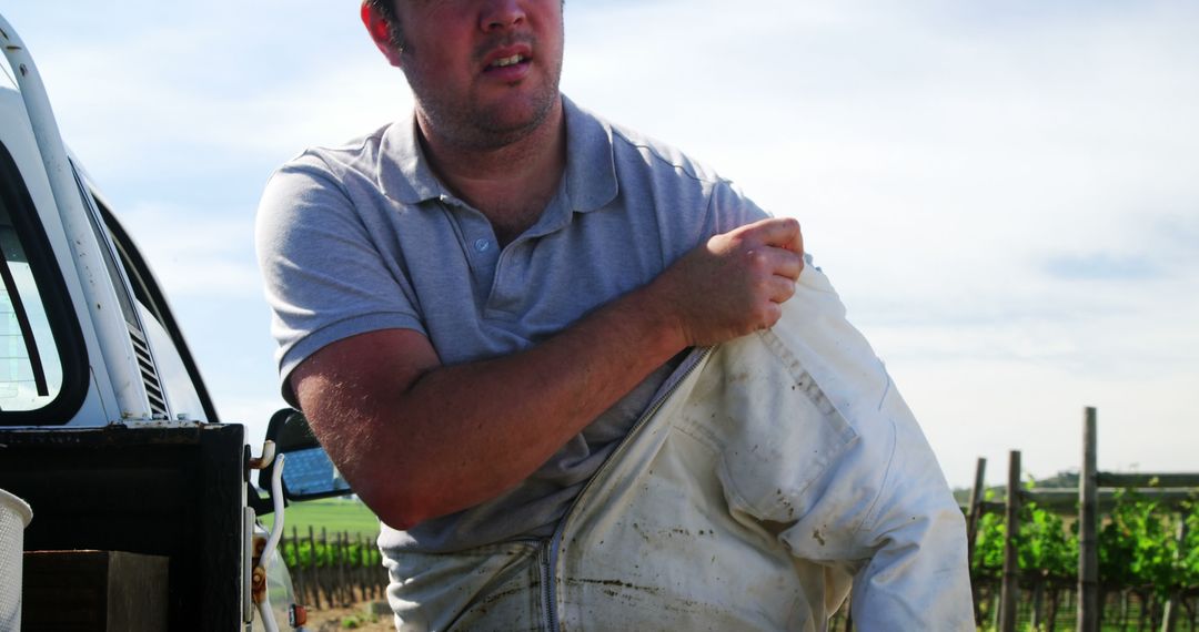 Farmer Putting on Protective Gear Near Vineyard - Free Images, Stock Photos and Pictures on Pikwizard.com