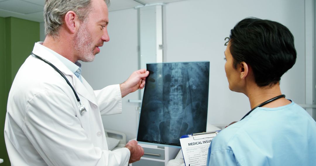 Male Doctor and Female Nurse Examining Spinal X-Ray in Hospital Room - Free Images, Stock Photos and Pictures on Pikwizard.com